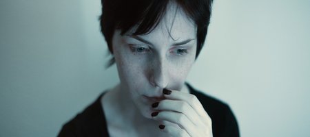 Portrait einer nachdenklichen Frau in dunklen Blautönen